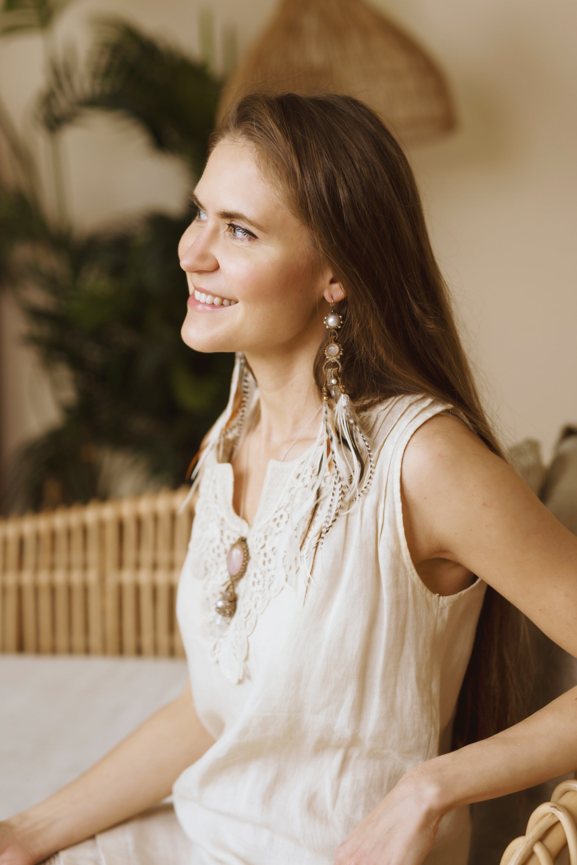 Model wearing Feather Earrings: Unique design on a woman looking to the side, embodying love, intention, and intricate knots.