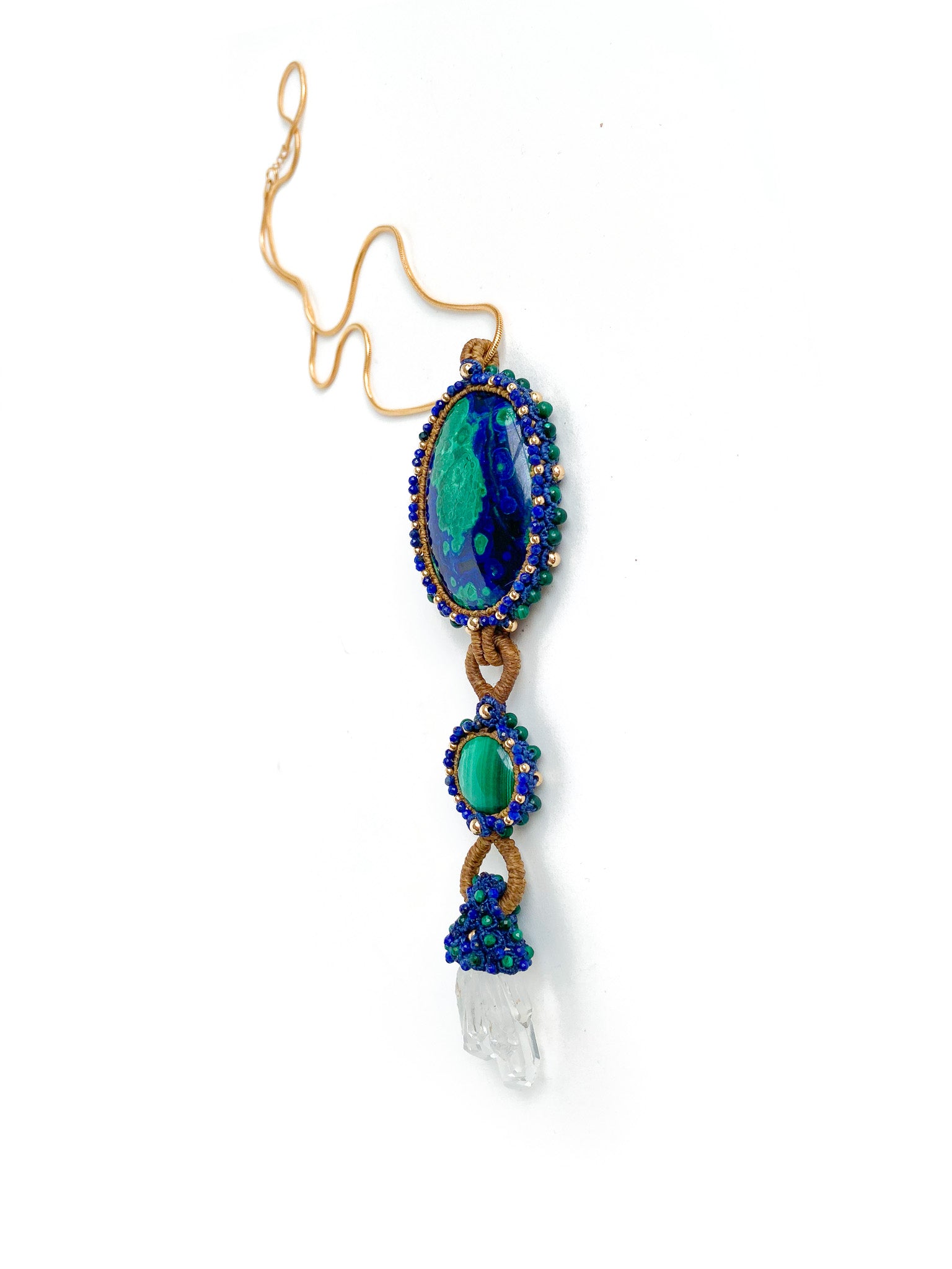 A side view of: Handcrafted Azure Key Amulet from the You Are The Key Collection, featuring Malachite, Azurite, Clear Quartz, Lapis, and Gold filled silver. A symbol of enlightened leadership and insight. Adorned with a 1.5mm snake chain, 20 inches. Includes a custom silk bag for safekeeping. Experience the essence of the Azure Key—a unique blend of gemstones for personal transformation