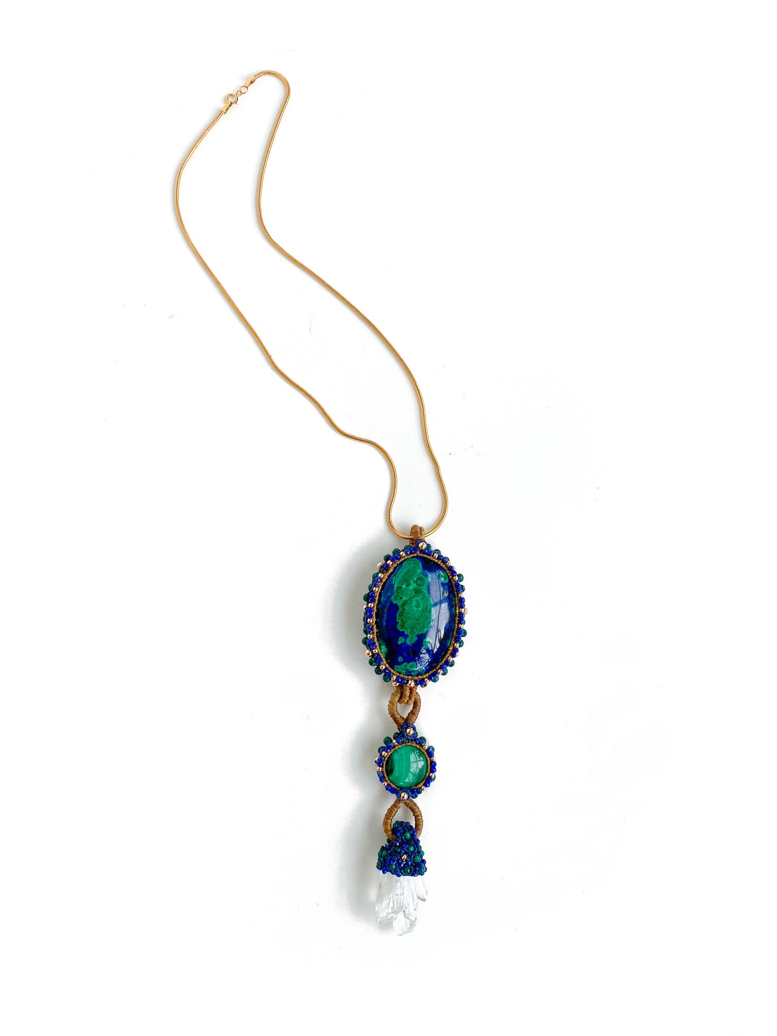 Far away view of: Handcrafted Azure Key Amulet from the You Are The Key Collection, featuring Malachite, Azurite, Clear Quartz, Lapis, and Gold filled silver. A symbol of enlightened leadership and insight. Adorned with a 1.5mm snake chain, 20 inches. Includes a custom silk bag for safekeeping. Experience the essence of the Azure Key—a unique blend of gemstones for personal transformation.