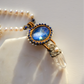 Necklace with blue gemstone and crystal pendant on a white background