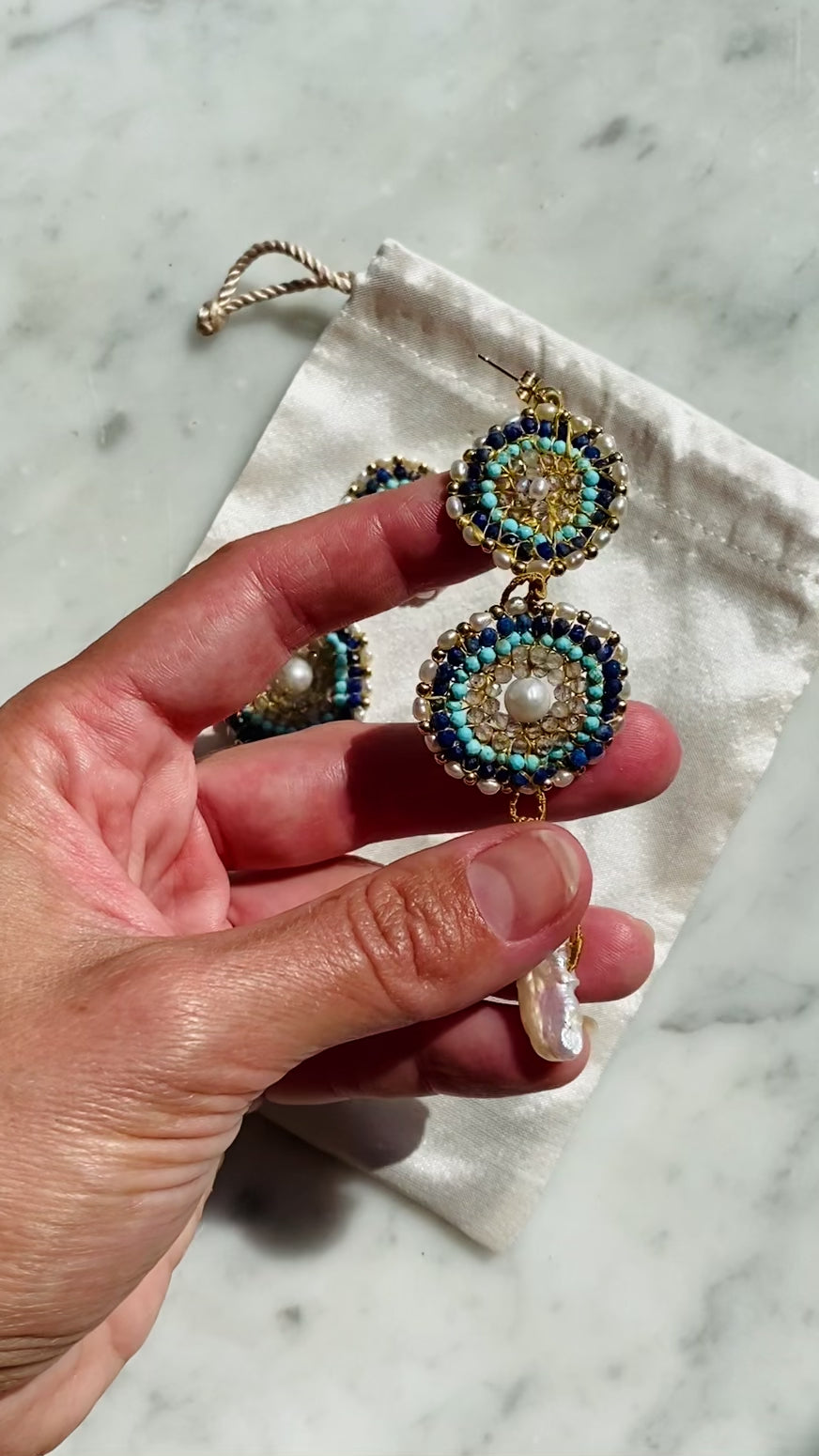 A video of detailed beadwork for Water Key Gemstone Earrings from the You Are The Key Collection - Handcrafted with care, featuring gemstones such as Turquoise, Labradorite, and Pearl for personal transformation. A cool, calming touch with a sense of freshness. Each piece includes a custom silk bag, guided meditation, and instruction video. 