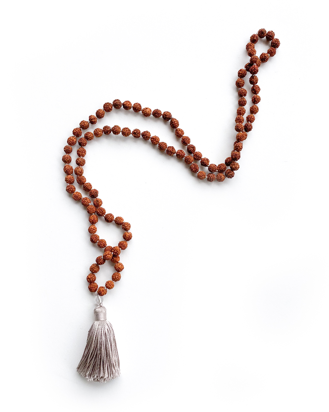 Rudraksha & Quartz 108 Meditation Mala. Handcrafted to align with your higher self, silk knots hold affirmations, enhancing your practice. Sacred Numerology adorned with healing gemstones; each piece includes a silk bag & guided meditation. Made to order for your awakening journey. Showing full length, on a white background.