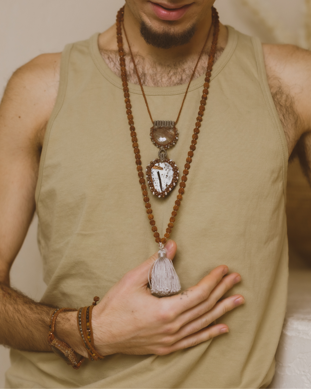 Rudraksha & Quartz 108 Meditation Mala. Handcrafted to align with your higher self, silk knots hold affirmations, enhancing your practice. Sacred Numerology adorned with healing gemstones; each piece includes a silk bag & guided meditation. Made to order for your awakening journey. On a model. 