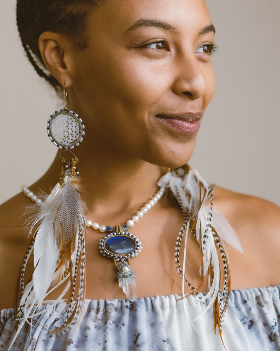 Front view of a model wearing Feather Earrings – a unique necklace with Spectrolite, Freshwater Pearl, Clear Quartz, Lapis, & Silver, opening hearts with love and intention.